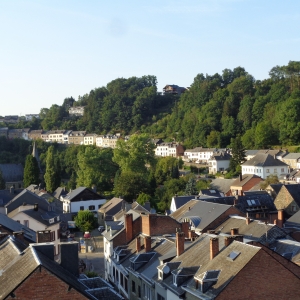 Le Thier des Cochons, au-delà de la crête de feuillus dominant la rue escarpée du Bois des Moines, ancienne route de Liège.