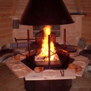 Installes sur des banquettes en bois recouvertes de peaux de rennes .les assiettes et les couverts sont en bois d'aulne .Les tasses sont en bois egalement .Chaque convive peut cuire devant lui ses viandes ou poissons dans une ambiance conviviale assuree  